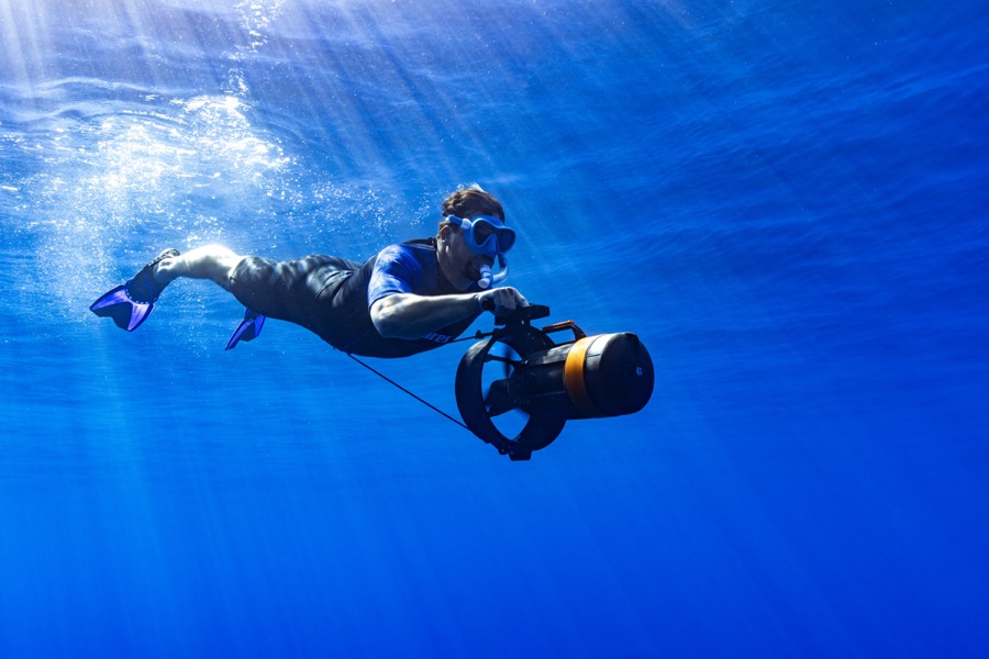 Participant gliding underwater with a DPV scooter