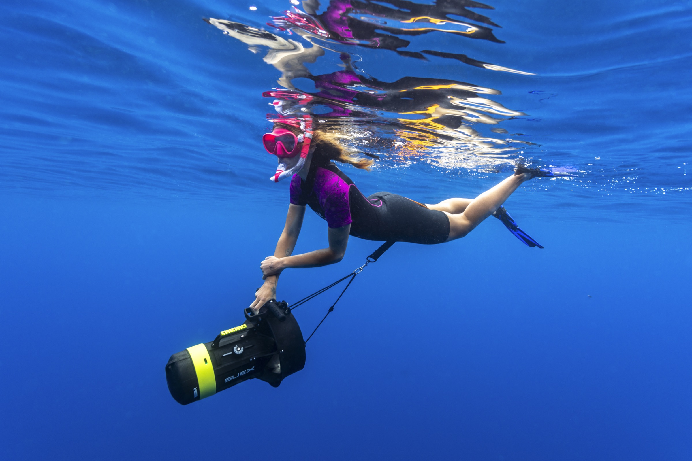 Snorkeller gliding at the surface with a DPV scooter